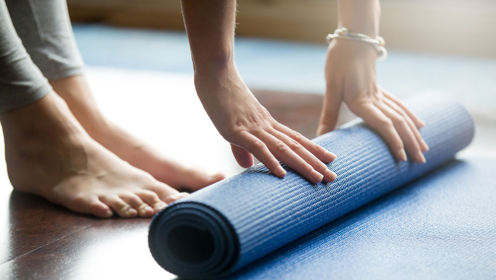 Woman unrolling yoga mat