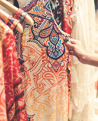 Woman's hand touching clothing at a boutique