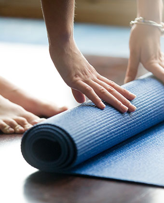 Woman unrolling a yoga mat