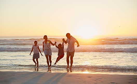 family on beach at sunset