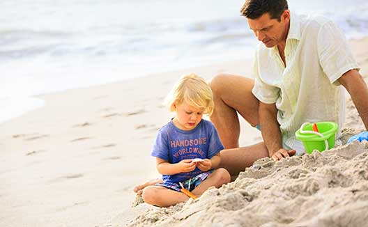 Dad watched son dig in the sand on the beach